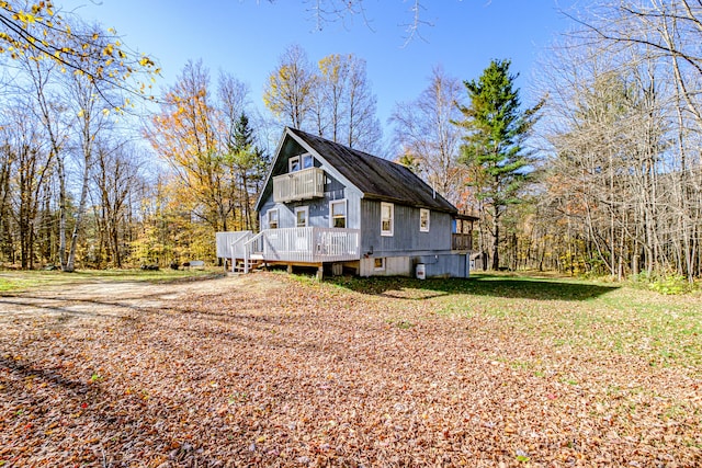 view of side of home featuring a wooden deck and a lawn