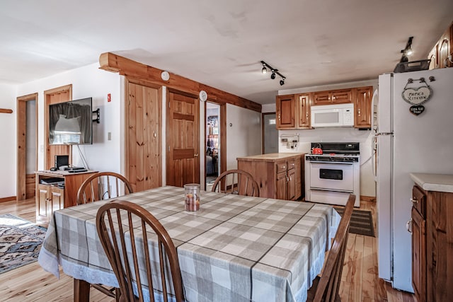 kitchen with white appliances, light hardwood / wood-style floors, and rail lighting