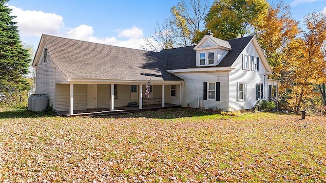 cape cod house featuring covered porch and a front yard