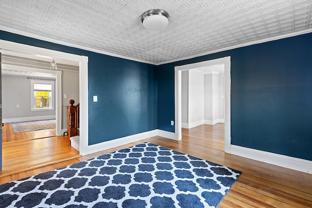 unfurnished room featuring crown molding and hardwood / wood-style flooring