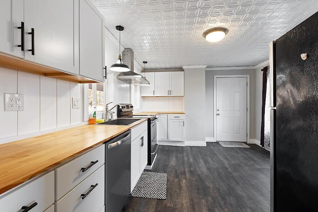 kitchen with a sink, stainless steel appliances, an ornate ceiling, dark wood finished floors, and white cabinetry