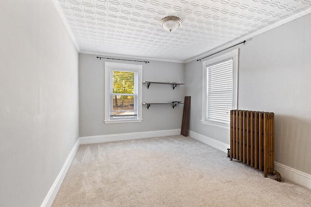 carpeted spare room with ornamental molding and radiator heating unit