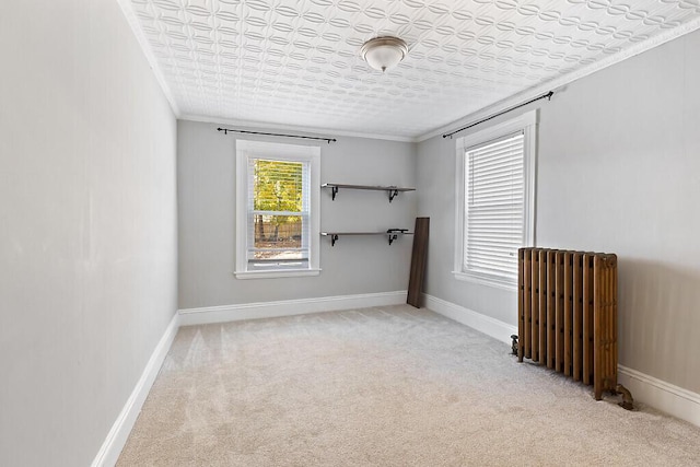 empty room featuring crown molding, radiator, baseboards, and carpet