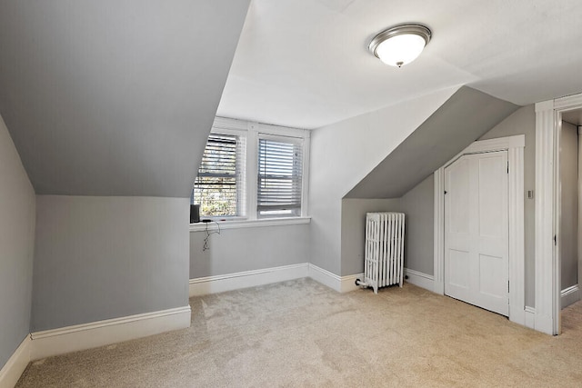 bonus room with light carpet, lofted ceiling, and radiator heating unit