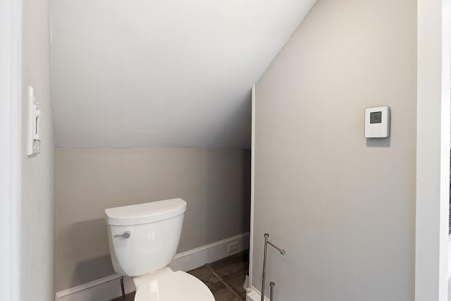 bathroom featuring lofted ceiling, wood-type flooring, and toilet