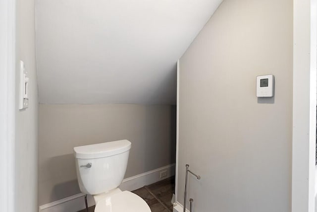 bathroom featuring toilet, baseboards, lofted ceiling, and wood finished floors