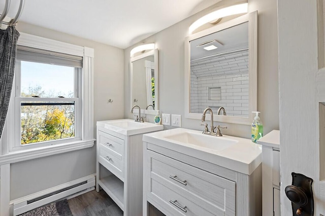 bathroom with a wealth of natural light, a baseboard radiator, and a sink