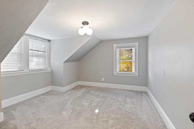 additional living space with carpet, vaulted ceiling, and baseboards