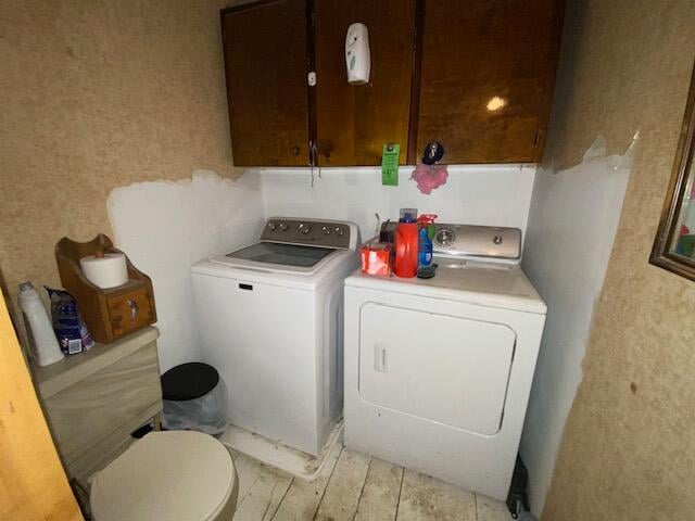 clothes washing area featuring washer and clothes dryer and light hardwood / wood-style floors