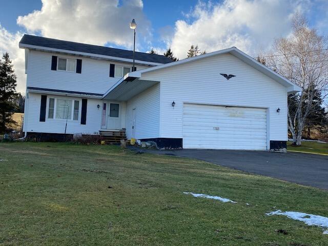 view of front of home with a garage and a front lawn