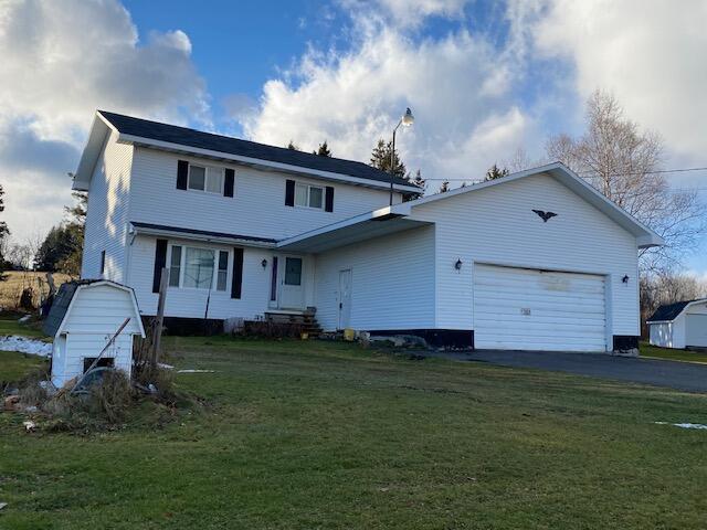 1388 Van Buren Rd, Connor Twp, ME 04736 - rear view of property featuring a lawn, a garage, and aphalt driveway