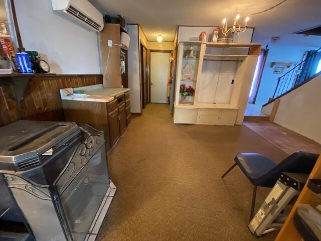 interior space featuring carpet, a wall mounted air conditioner, and an inviting chandelier