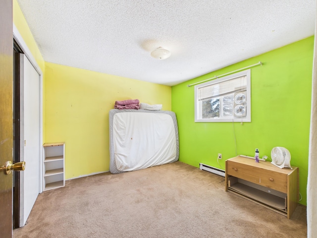 1388 Van Buren Rd, Connor Twp, ME 04736 - bedroom with a baseboard radiator, a textured ceiling, carpet, and a closet