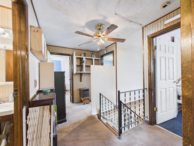 1388 Van Buren Rd, Connor Twp, ME 04736 - corridor featuring carpet flooring, an upstairs landing, a textured ceiling, and wooden walls