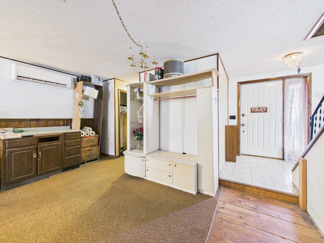 1388 Van Buren Rd, Connor Twp, ME 04736 - unfurnished bedroom featuring hardwood / wood-style flooring, a textured ceiling, a wall unit AC, and a wainscoted wall