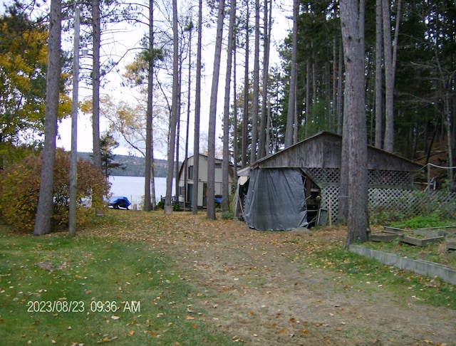 view of yard featuring a water view and an outbuilding