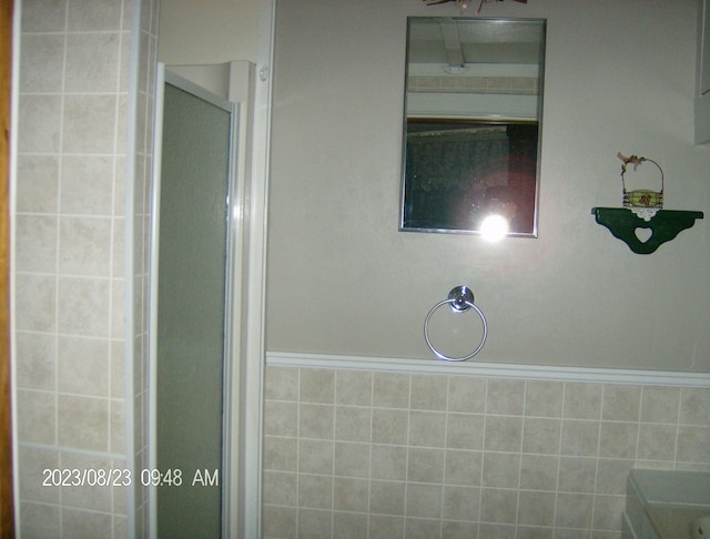 bathroom with walk in shower and tile walls