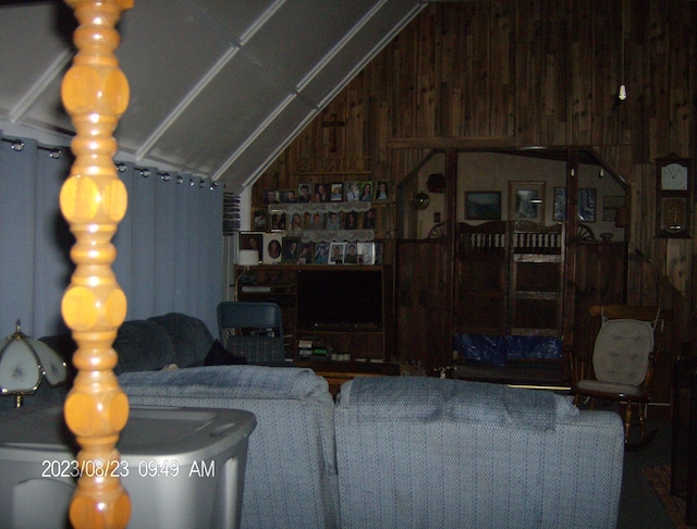 living room with wood walls and lofted ceiling