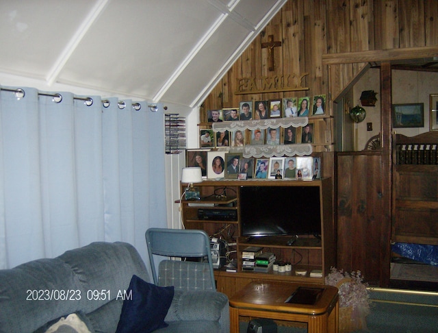 living room with lofted ceiling and wooden walls