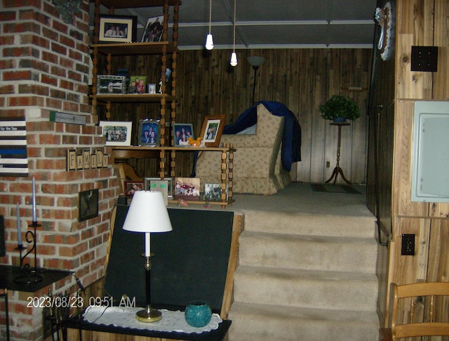 staircase featuring carpet flooring and wooden walls