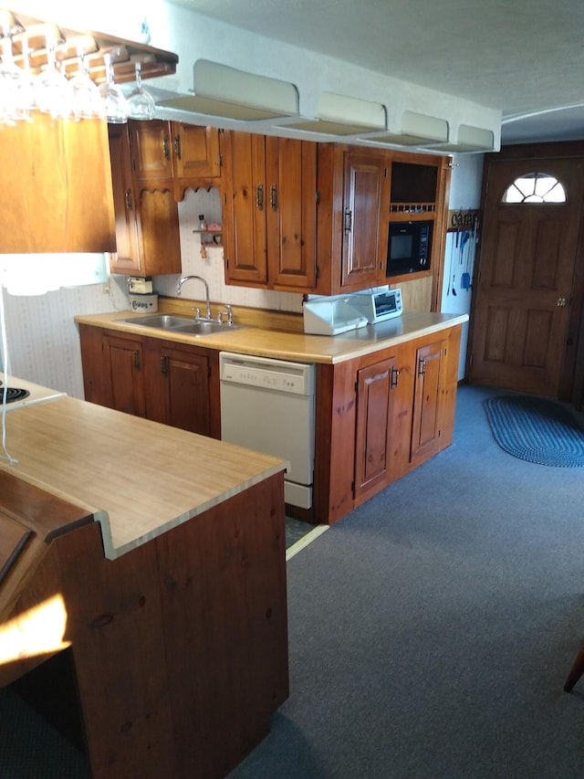 kitchen featuring white dishwasher, sink, carpet, and black microwave