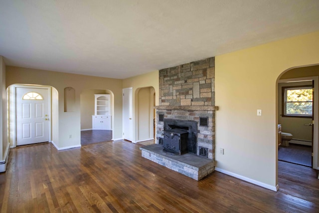 32 Morison Ave, Wells, ME 04090 - unfurnished living room with a baseboard heating unit, arched walkways, wood finished floors, and baseboards