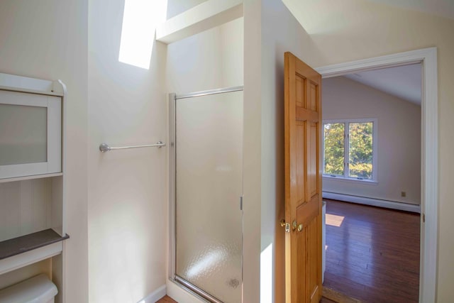 32 Morison Ave, Wells, ME 04090 - bathroom with wood finished floors, a baseboard radiator, vaulted ceiling, toilet, and a stall shower