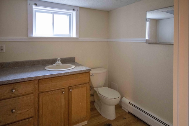 32 Morison Ave, Wells, ME 04090 - half bath with wood finished floors, vanity, toilet, and a baseboard heating unit