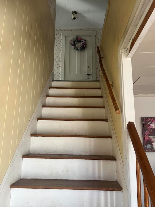 stairs featuring wooden walls