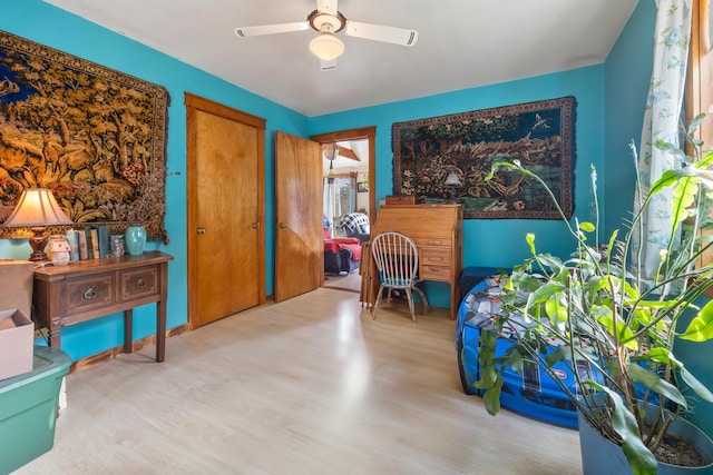 living area featuring light wood-type flooring and ceiling fan