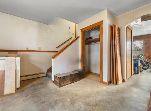 stairs with concrete flooring and a baseboard heating unit