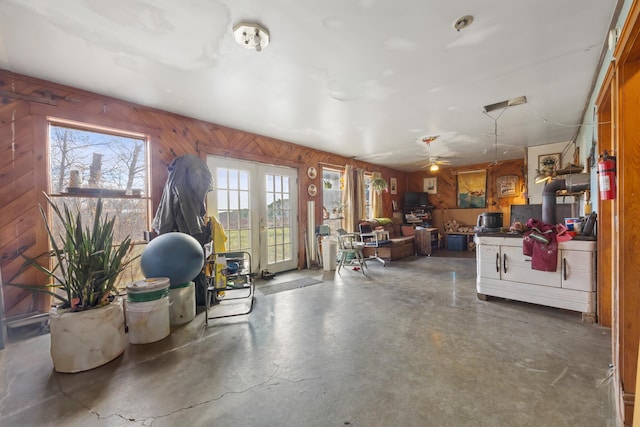 interior space with ceiling fan and wood walls