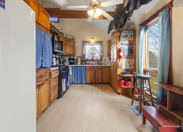 kitchen featuring ceiling fan, black appliances, vaulted ceiling, and light hardwood / wood-style floors