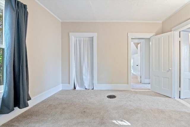 carpeted empty room featuring ornamental molding and a textured ceiling