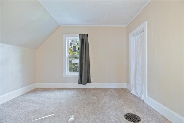 additional living space featuring lofted ceiling and light carpet