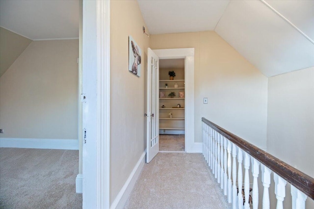 corridor featuring vaulted ceiling and light colored carpet