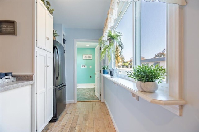 corridor with light hardwood / wood-style flooring