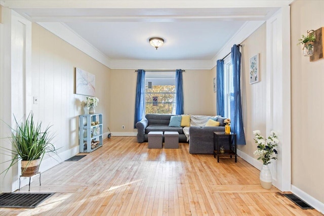 living area with hardwood / wood-style flooring and ornamental molding