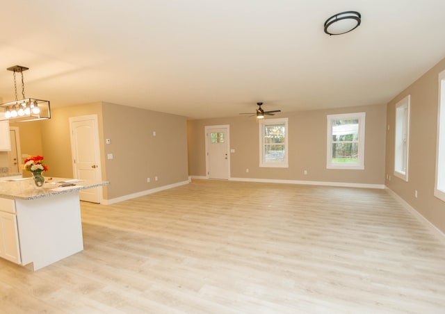 unfurnished living room featuring light hardwood / wood-style flooring and ceiling fan