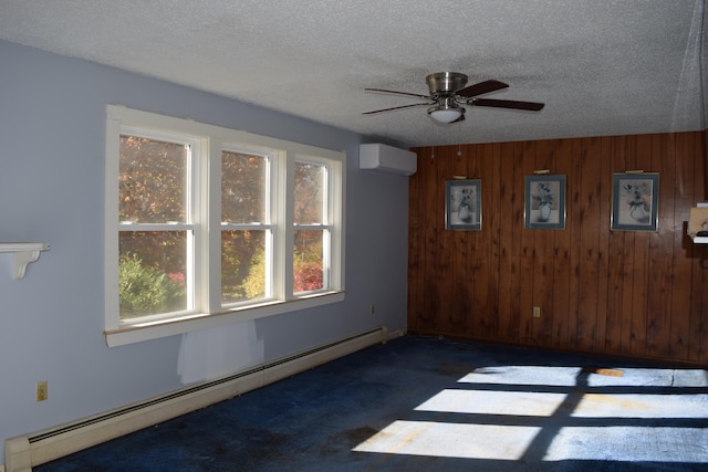 empty room with a wall unit AC, wooden walls, a baseboard radiator, a textured ceiling, and ceiling fan