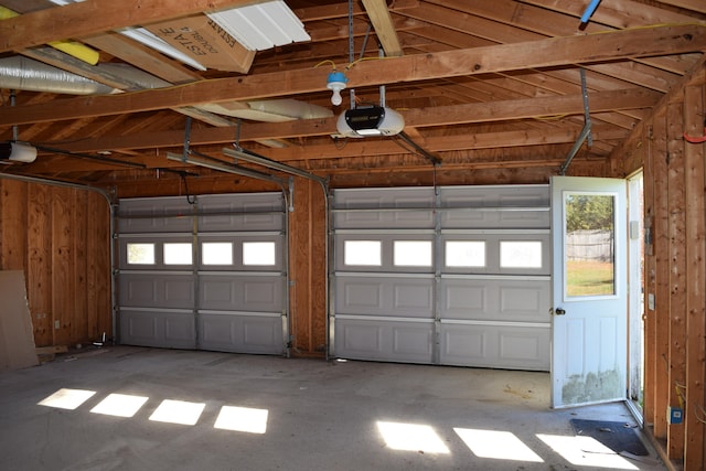 garage featuring a garage door opener and wood walls