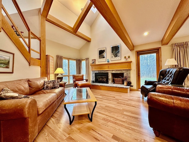 6071 Village On The Green Rd Unit G-11, Carrabassett Valley, ME 04947 - living room with beam ceiling, light wood-type flooring, a stone fireplace, and high vaulted ceiling