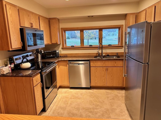 6071 Village On The Green Rd Unit G-11, Carrabassett Valley, ME 04947 - kitchen with stainless steel appliances, a sink, dark stone countertops, and brown cabinets