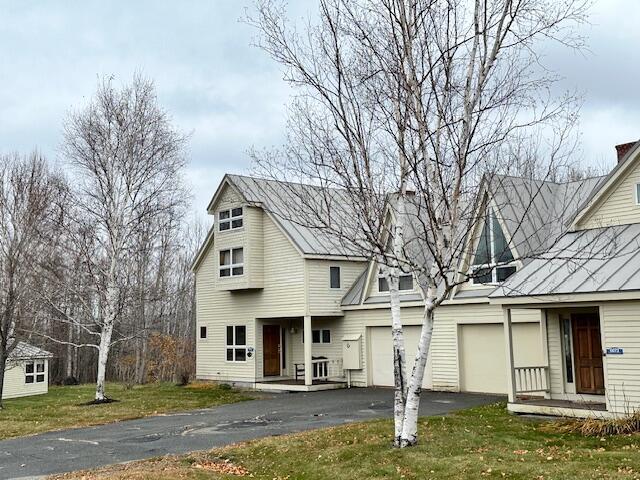 6071 Village On The Green Rd Unit G-11, Carrabassett Valley, ME 04947 - view of front of house featuring asphalt driveway, a front lawn, and an attached garage