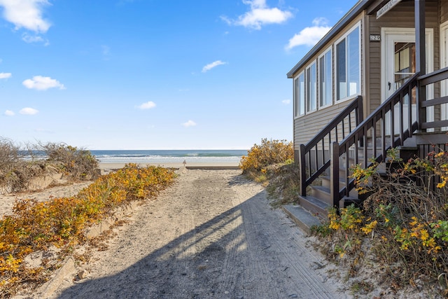 exterior space with a water view and a beach view