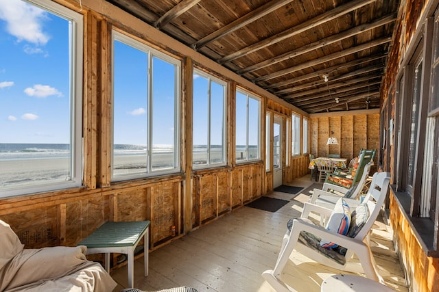 sunroom featuring a water view, wooden ceiling, lofted ceiling, and a beach view