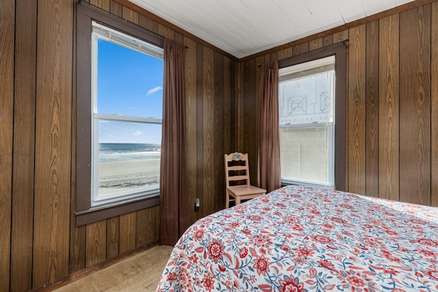 bedroom with wooden walls and a water view