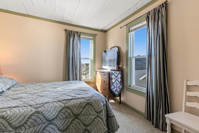 bedroom featuring wood ceiling, ornamental molding, and multiple windows