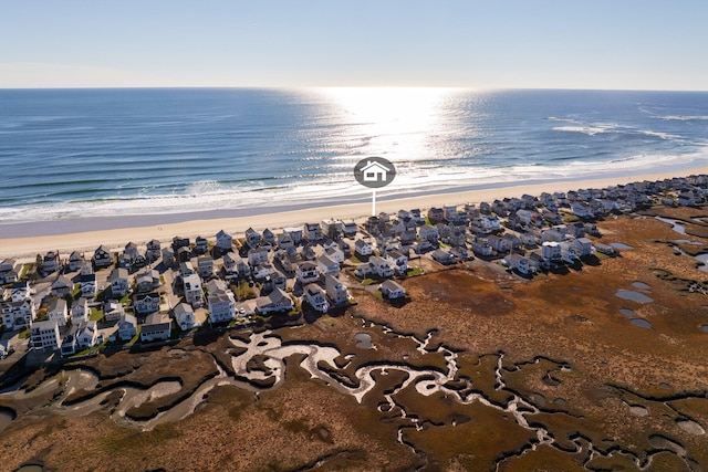 birds eye view of property with a water view and a beach view