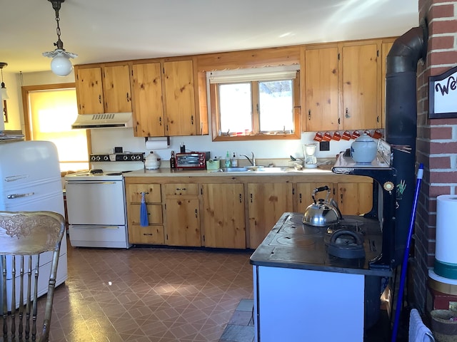 kitchen with dark tile patterned floors, hanging light fixtures, sink, electric range, and refrigerator